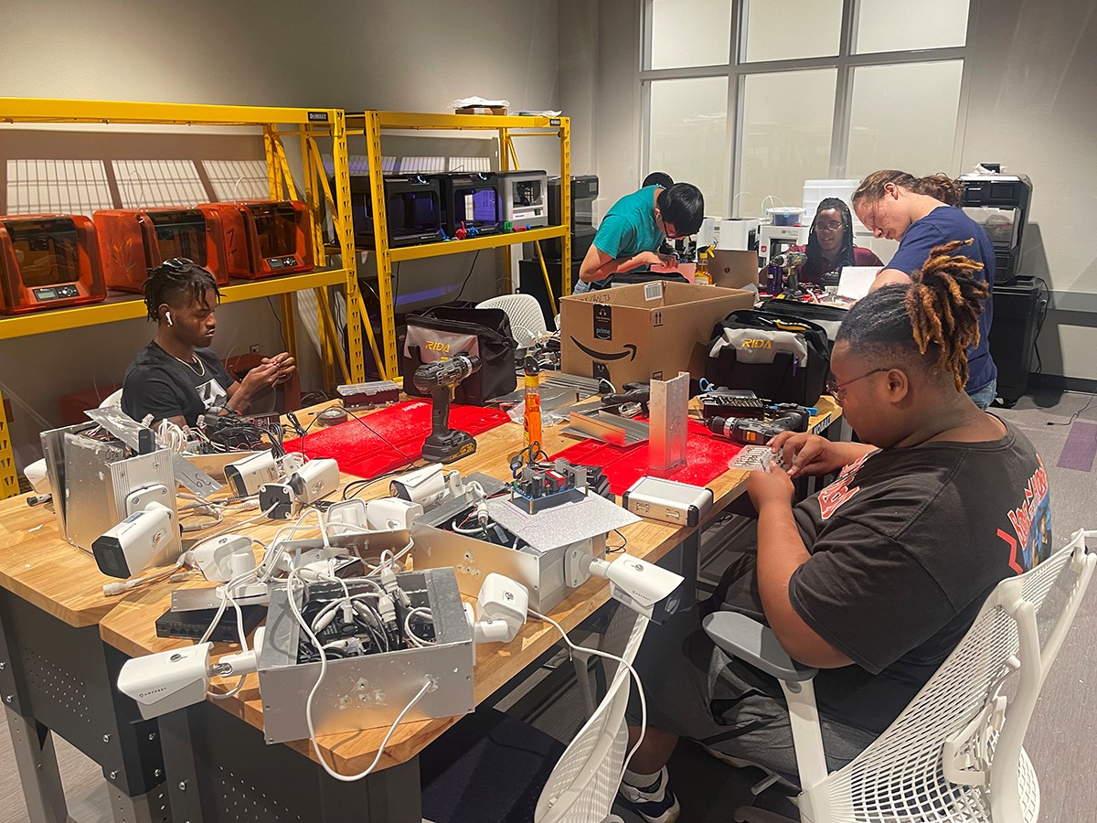 News and Events/2022 News Images/09 08 22 building cameras.jpg 4 male students and a female supervisor build camera boxes in the lsus cyber collaboratory for the shreveport real time crime center